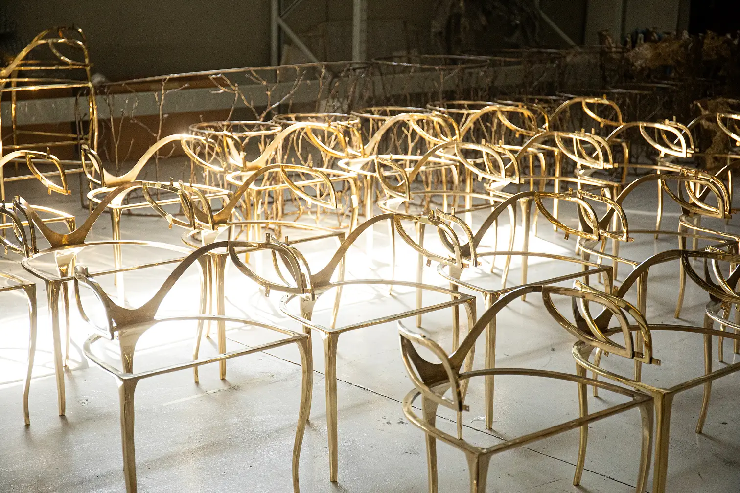Golden metallic frames of Chandra Chairs, showcasing their sculptural construction.